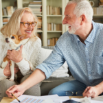 April 25 Events Page Image - Acacia Springs Elderly man and his wife smiling and holding small dog